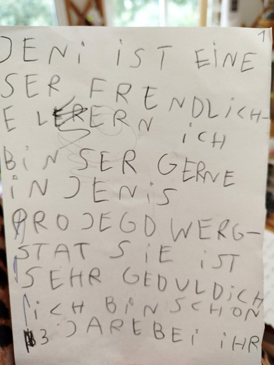 Auf einem Zettel steht: Jenny ist eine sehr freundliche Lehrerin. Ich bin sehr gerne in Jennys Projektwerkstatt.